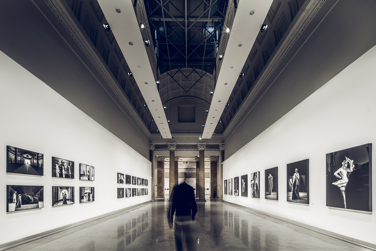 Long corridor — visitor passing the portrait series