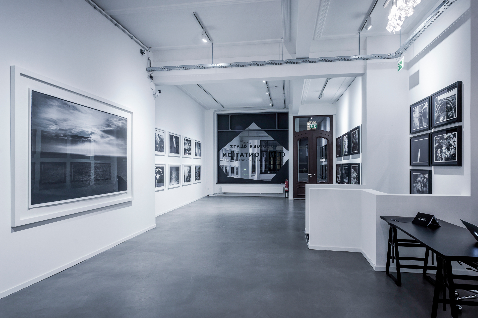 Installation detail — framed works set against a dark wall